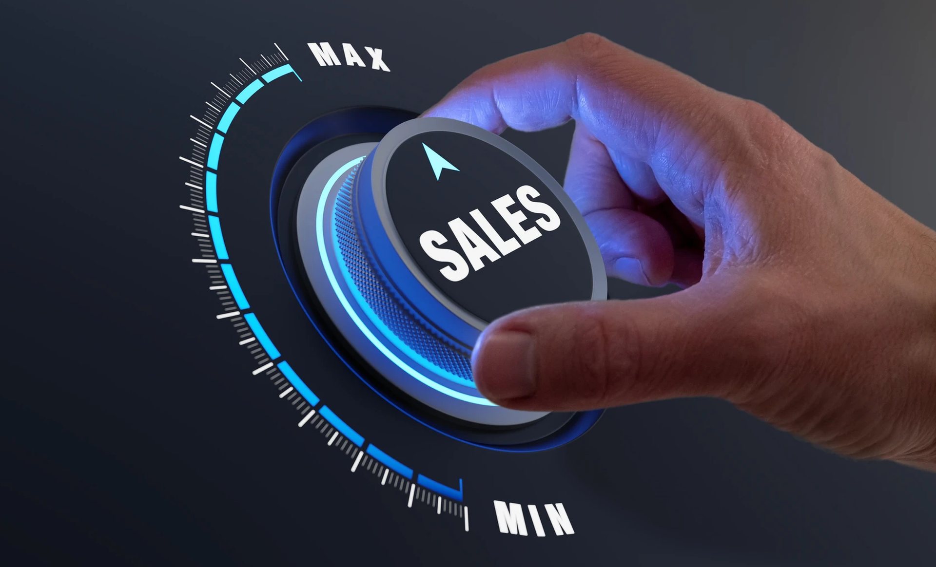A hand turning a glowing SALES dial from min toward max